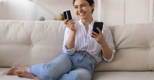 Imagem ilustrativa de uma pessoa segurando um cartão de crédito rodeado por ícones de cashback e benefícios.