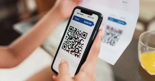 Mão segurando smartphone com tela de pagamento PIX de boleto. Segurança e eficiência nas transações financeiras.