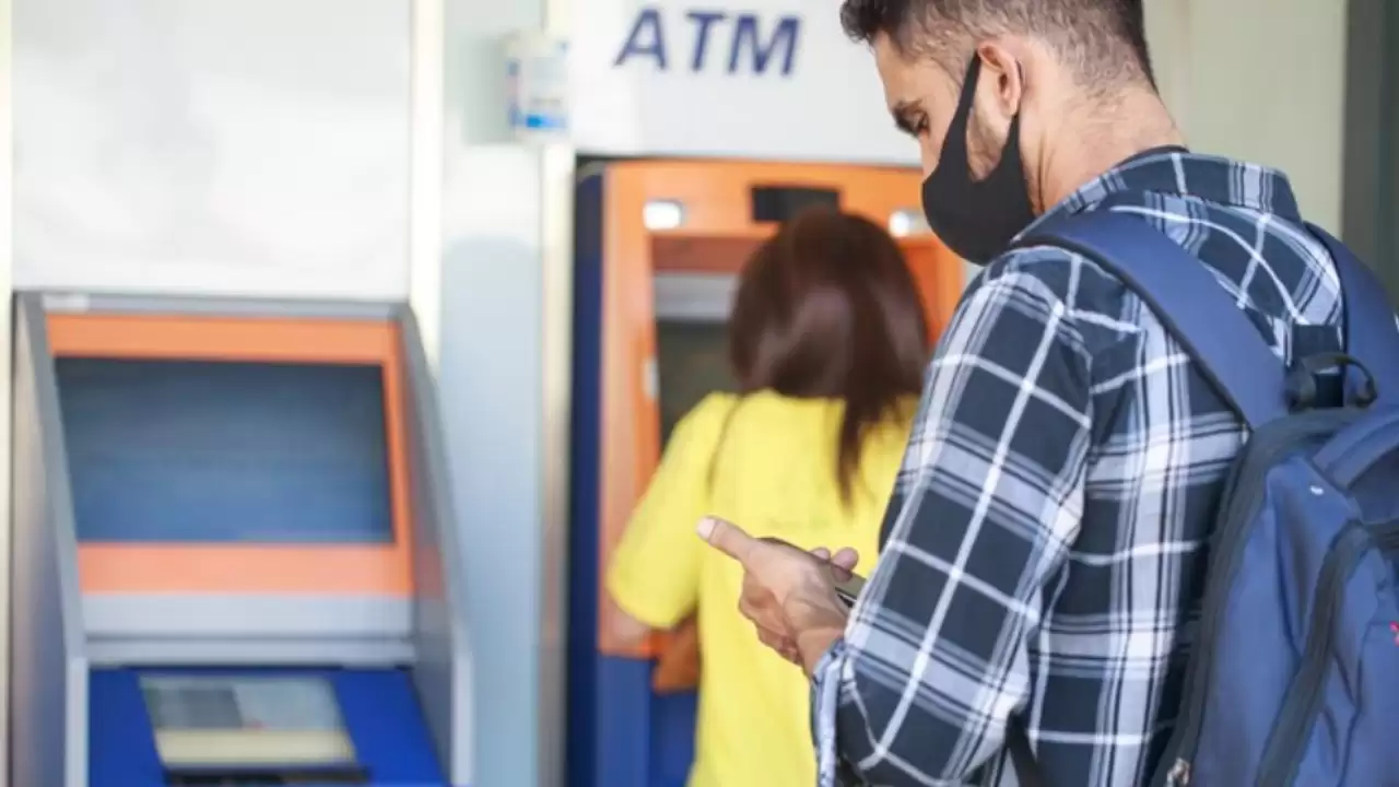 Pessoas realizando saque em caixa eletrônico, representando a praticidade e segurança do saque sem cartão.