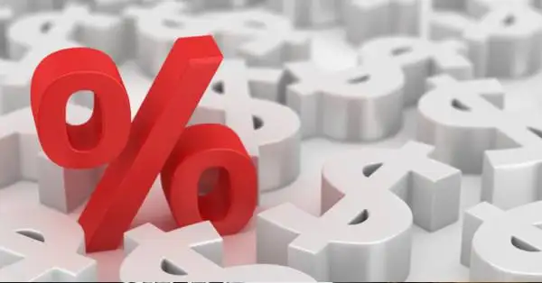 magem representando gráficos financeiros, moedas e uma calculadora, ilustrando o impacto das taxas de juros nas finanças pessoais.